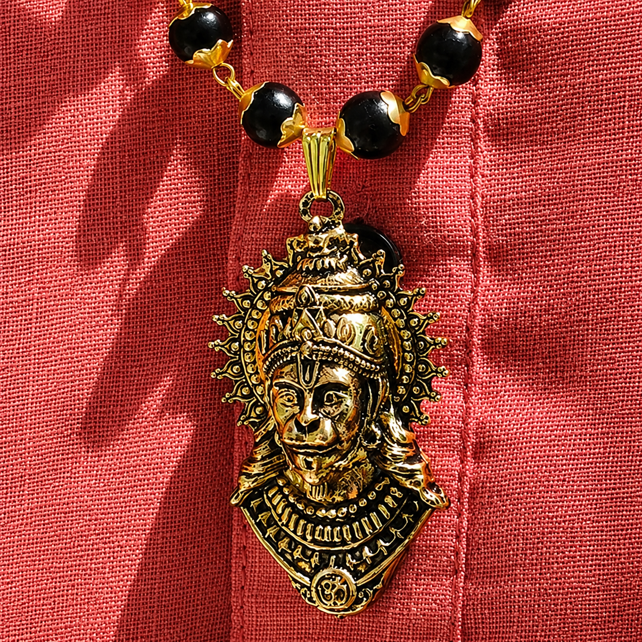 Decorative BajrangBali Pendant Karungali Mala on a red fabric background