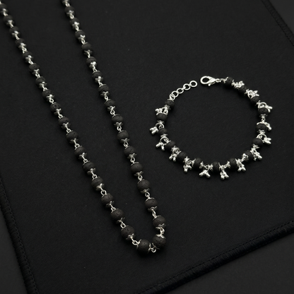 Karungali Silver Plated necklace and bracelet on a black textured surface