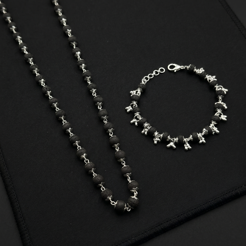 Karungali Silver Plated necklace and bracelet on a black textured surface