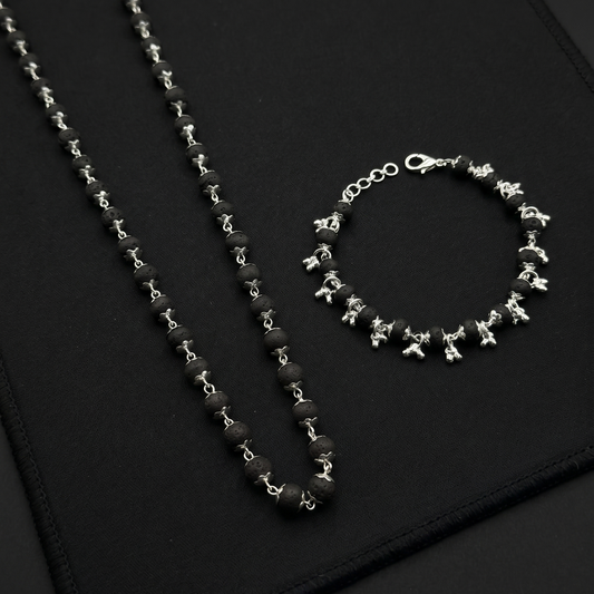 Karungali Silver Plated necklace and bracelet on a black textured surface