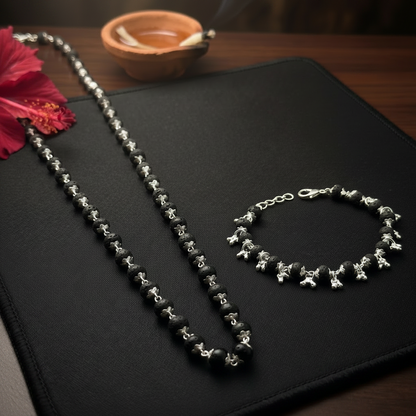 Silver Plated Karungali necklace and bracelet set on a black surface with an incense in the background.