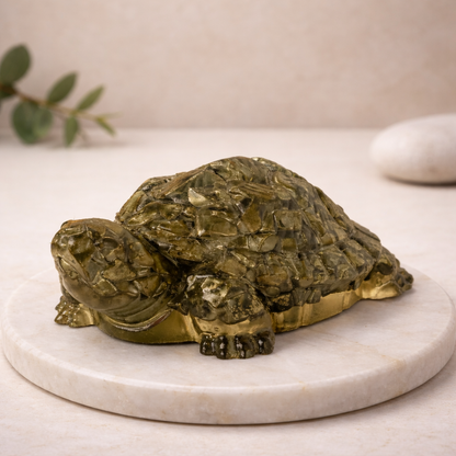 Pyrite turtle sculpture on a marble base with a neutral background