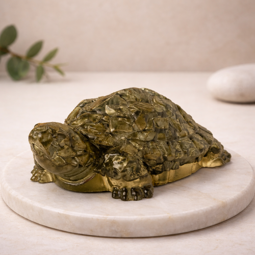Pyrite turtle sculpture on a marble base with a neutral background