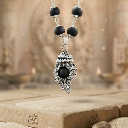 Shankh Pendant Karungali Necklace with black beads and a silver pendant on a stone surface with a blurred background
OM Shankh Karungali Malai Necklace - Silver Plated