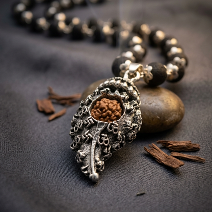 Shankh Pendant Rudraksha Karungali Necklace with a pendant on a dark fabric background